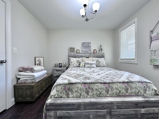 bedroom with dark wood-type flooring and an inviting chandelier