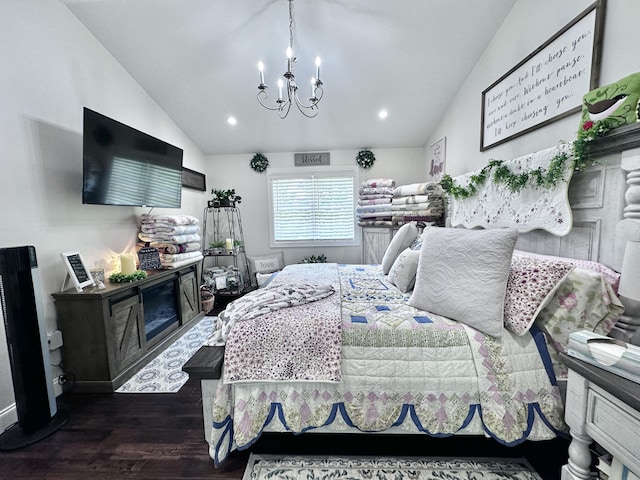 bedroom featuring dark hardwood / wood-style flooring, lofted ceiling, a notable chandelier, and a fireplace