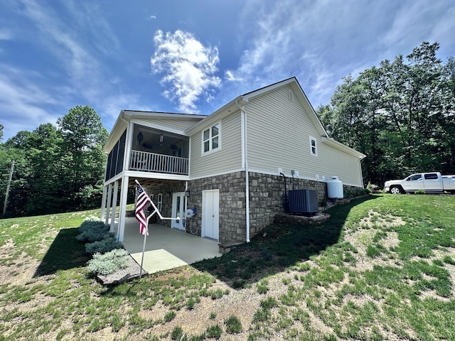 back of property featuring ceiling fan, central air condition unit, a patio area, a sunroom, and a yard