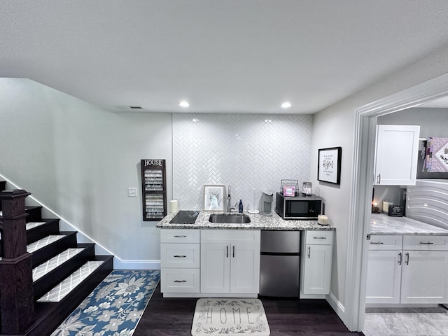 kitchen with white cabinets, fridge, and sink