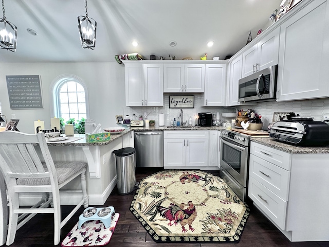 kitchen with white cabinetry, pendant lighting, and stainless steel appliances