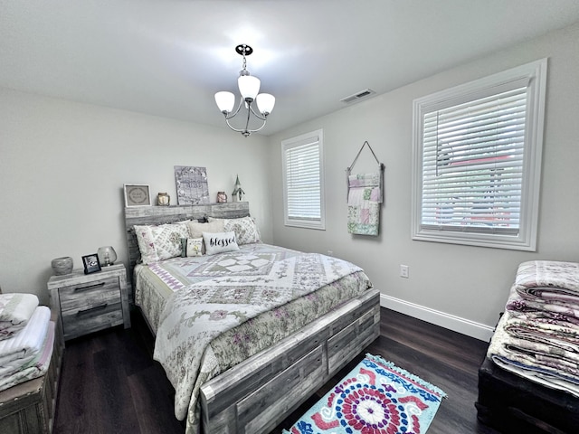 bedroom with dark wood-type flooring and a chandelier