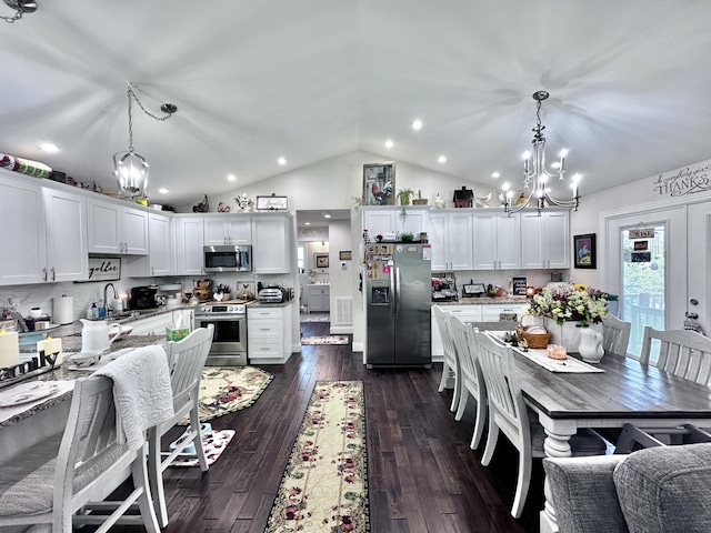 kitchen featuring white cabinets, hanging light fixtures, and appliances with stainless steel finishes