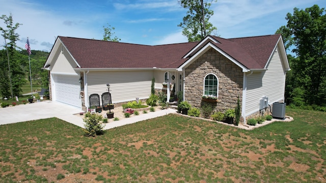 view of front facade featuring a front lawn, central air condition unit, and a garage