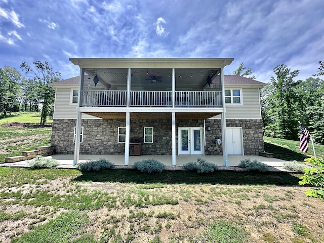 back of property with ceiling fan, a lawn, a balcony, and a patio