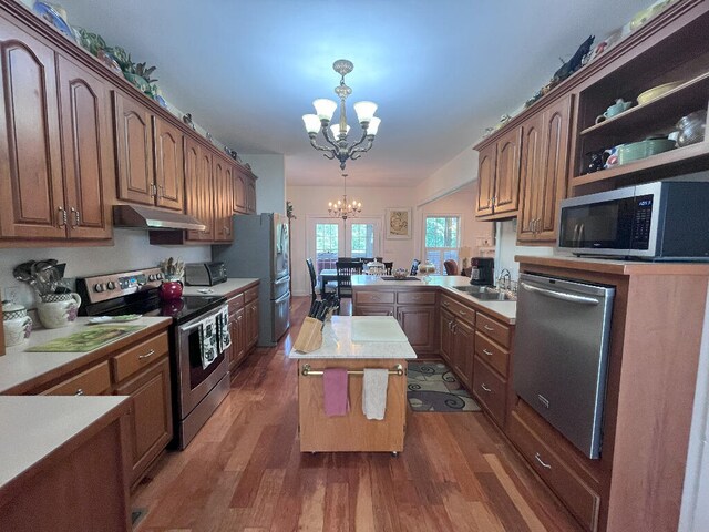 kitchen featuring an inviting chandelier, appliances with stainless steel finishes, dark hardwood / wood-style flooring, and a center island