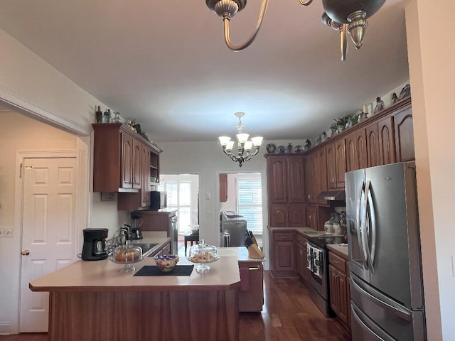 kitchen featuring decorative light fixtures, dark hardwood / wood-style flooring, stainless steel appliances, a notable chandelier, and sink