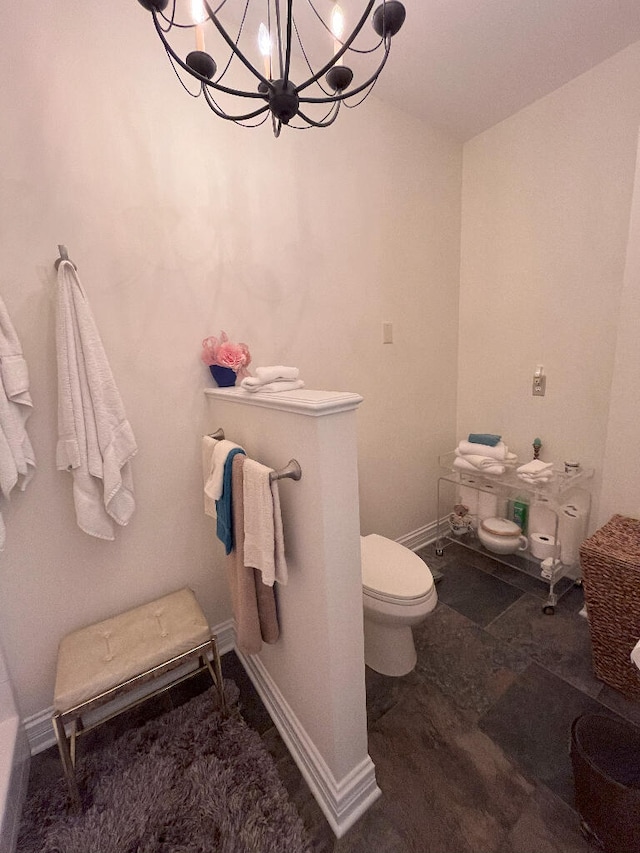 bathroom with a notable chandelier and toilet