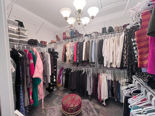 walk in closet featuring a notable chandelier and tile flooring