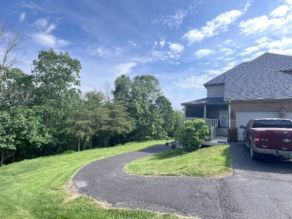 view of side of home featuring a garage and a yard