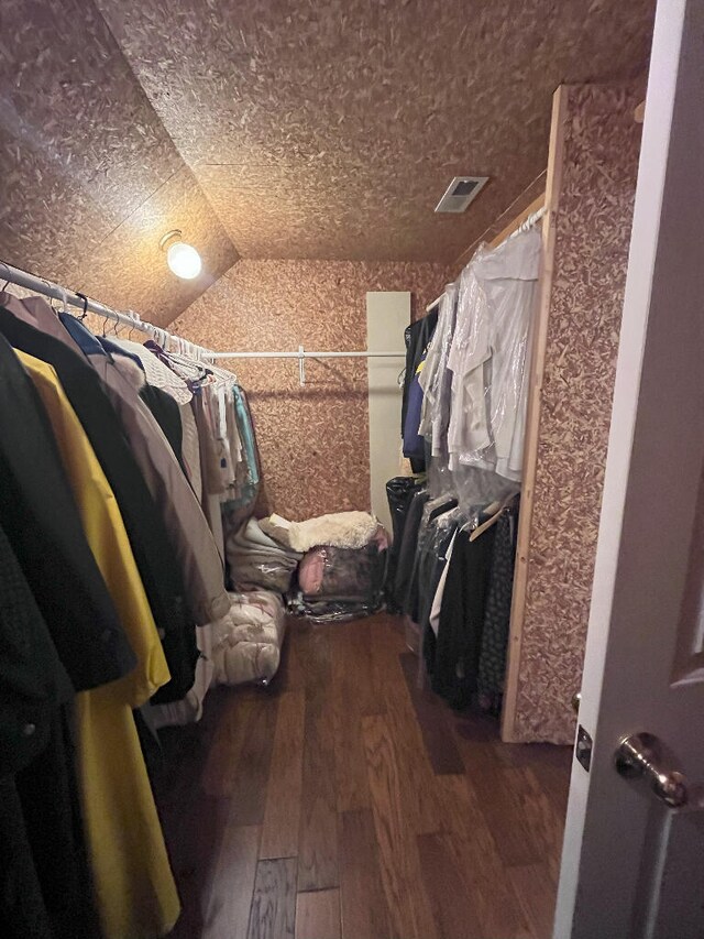 walk in closet featuring vaulted ceiling and hardwood / wood-style floors