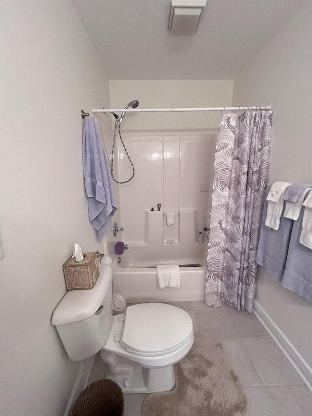 bathroom featuring tile flooring, shower / tub combo with curtain, and toilet