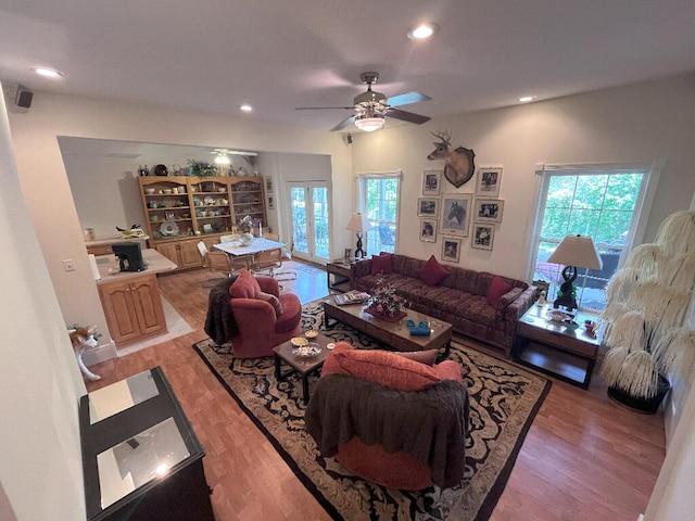 living room featuring french doors, ceiling fan, and light wood-type flooring