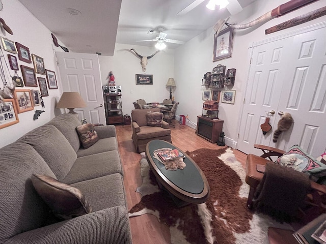 living room featuring wood-type flooring and ceiling fan