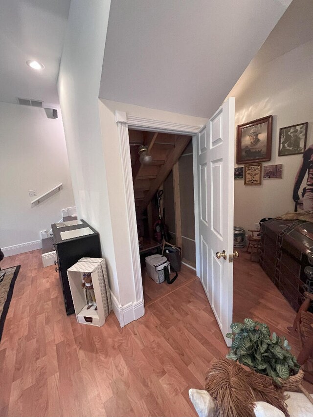 hall featuring lofted ceiling and hardwood / wood-style flooring