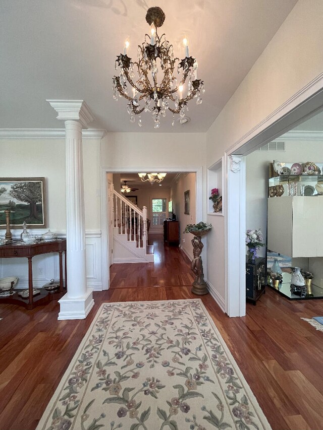 corridor featuring an inviting chandelier, hardwood / wood-style floors, and decorative columns