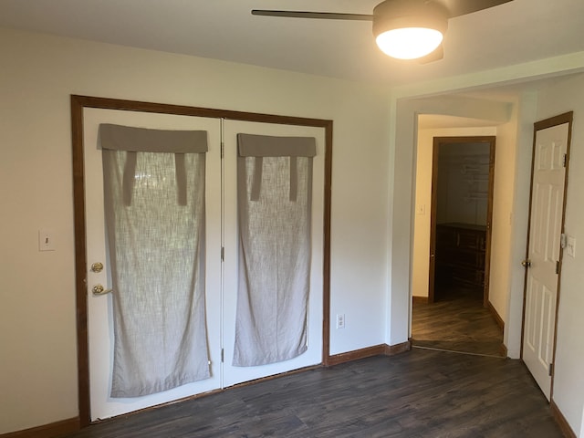 unfurnished bedroom with ceiling fan, dark hardwood / wood-style flooring, and a closet