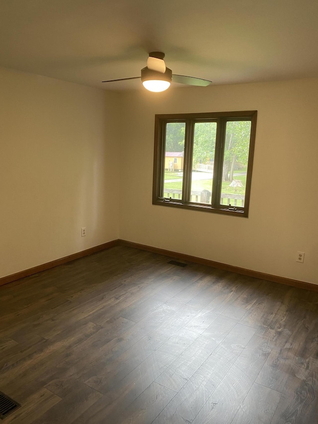 spare room featuring dark hardwood / wood-style floors and ceiling fan