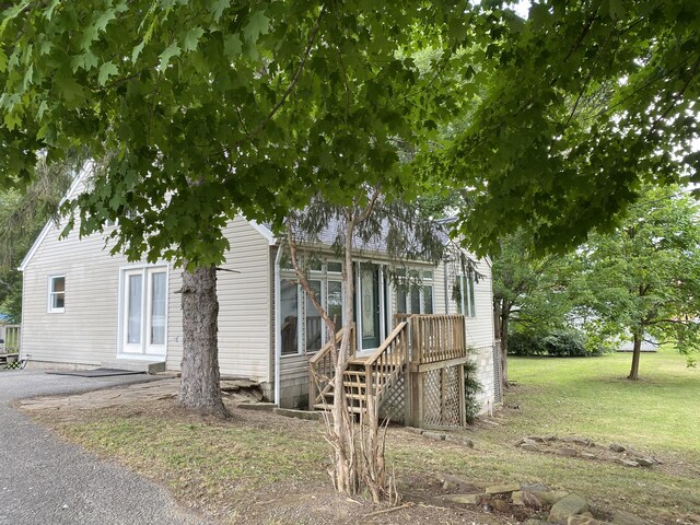 view of side of property with a lawn and a wooden deck