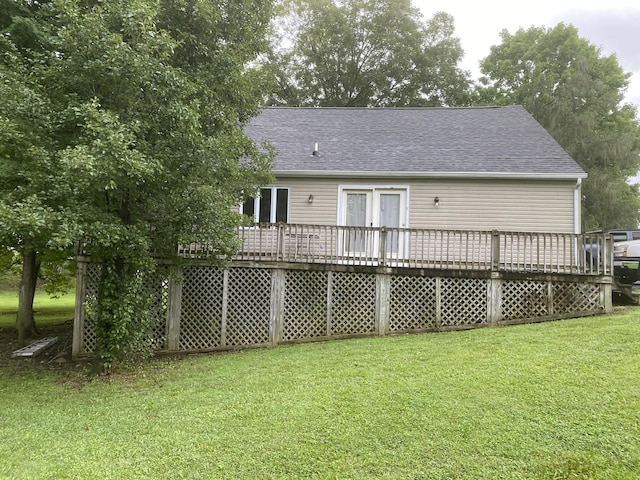 rear view of property featuring a yard and a deck