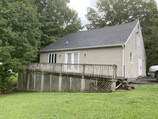 back of property featuring french doors, a deck, and a lawn