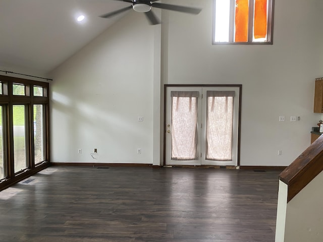 unfurnished living room featuring ceiling fan, plenty of natural light, dark wood-type flooring, and high vaulted ceiling