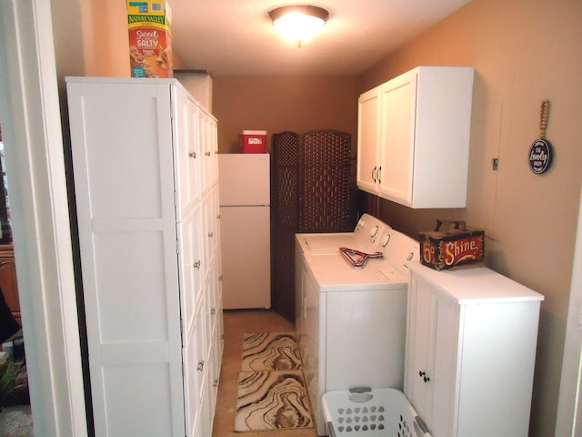 washroom with cabinets and washer and dryer