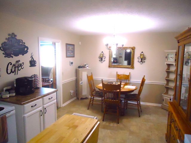 dining area featuring light carpet and an inviting chandelier