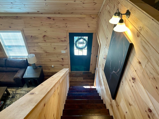 staircase featuring hardwood / wood-style flooring and wooden walls