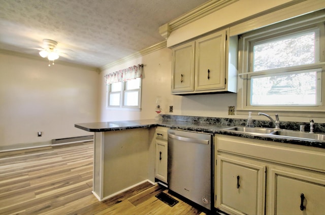 kitchen with sink, dishwasher, kitchen peninsula, and cream cabinetry