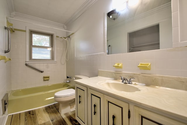 full bathroom with toilet, tiled shower / bath, tile walls, vanity, and hardwood / wood-style flooring