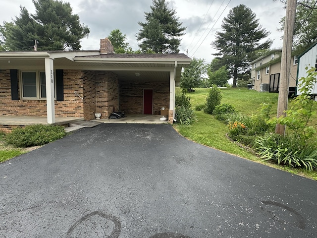 view of side of property featuring a yard and a carport