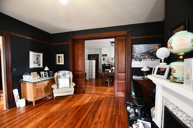 office space featuring a tiled fireplace and wood-type flooring