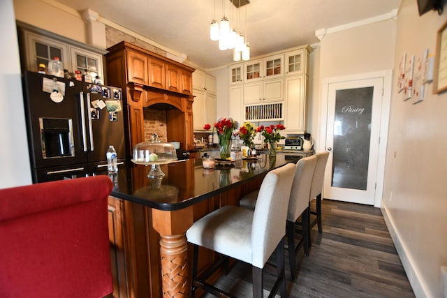 kitchen with decorative light fixtures, high end fridge, dark hardwood / wood-style floors, crown molding, and a center island