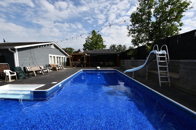 view of pool featuring a water slide and a patio area