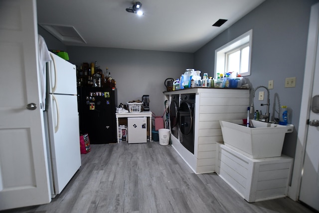 laundry area featuring washer and dryer and light hardwood / wood-style flooring