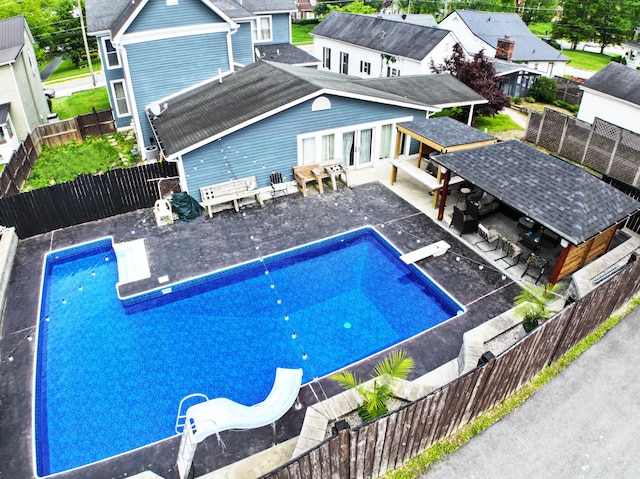 view of swimming pool with a patio area and a water slide