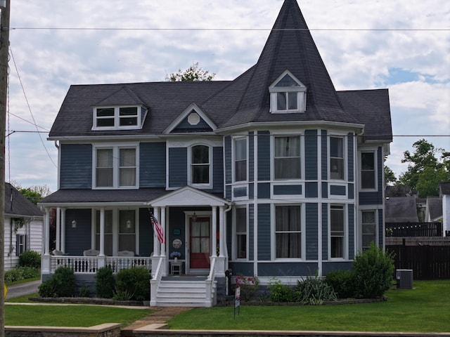 victorian house with a front lawn and central AC unit