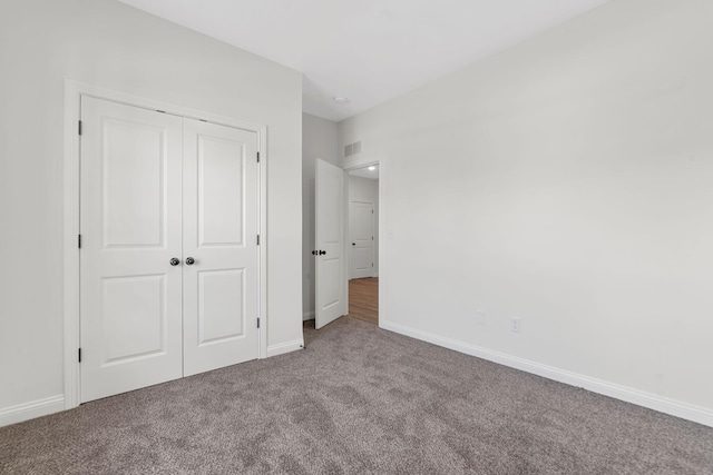 unfurnished bedroom with a closet and carpet flooring