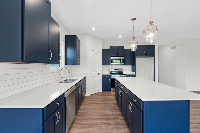 kitchen with sink, blue cabinets, a center island, and appliances with stainless steel finishes