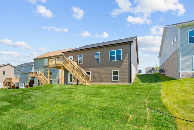 rear view of property featuring a wooden deck and a lawn