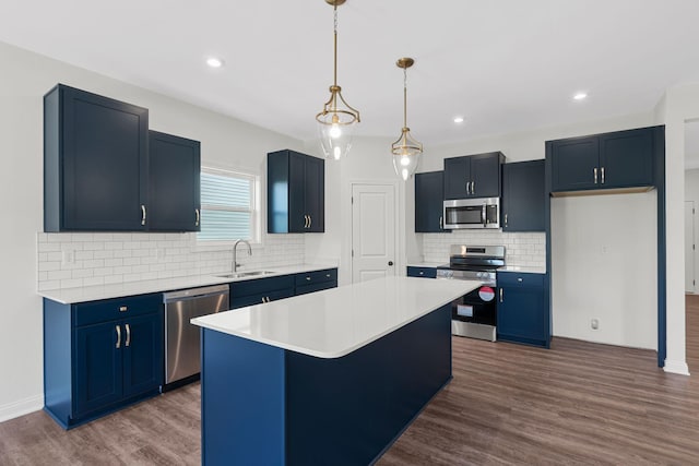 kitchen featuring appliances with stainless steel finishes, dark hardwood / wood-style flooring, a center island, and sink