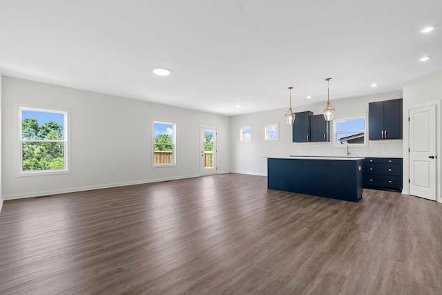 unfurnished living room with a healthy amount of sunlight and dark hardwood / wood-style flooring