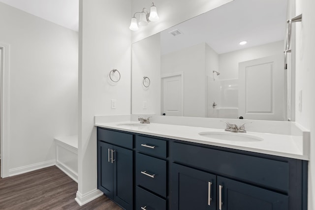 bathroom featuring walk in shower, vanity, and hardwood / wood-style flooring