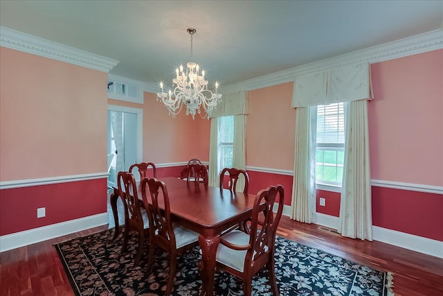 dining area with dark hardwood / wood-style floors, a notable chandelier, and ornamental molding