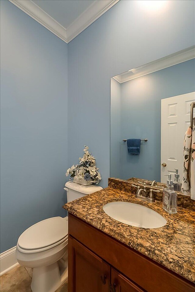 bathroom with tile flooring, crown molding, toilet, and vanity