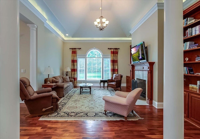 living room featuring dark hardwood / wood-style floors, ornamental molding, a chandelier, and decorative columns