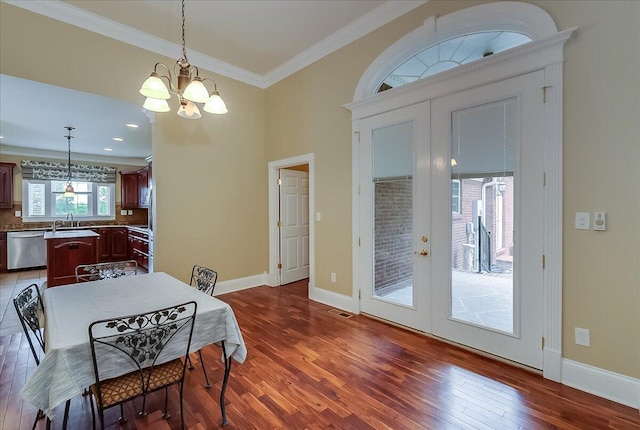 dining area with a chandelier, hardwood / wood-style flooring, french doors, and crown molding