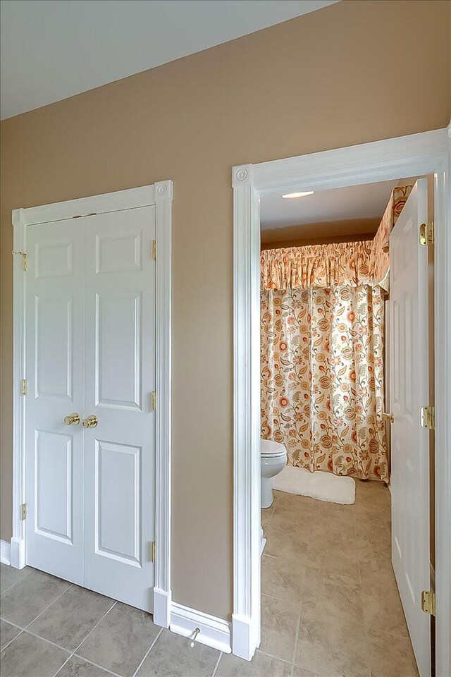 bathroom with tile flooring and toilet