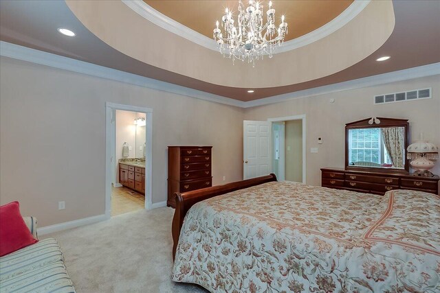 carpeted bedroom featuring a tray ceiling, crown molding, ensuite bathroom, and a chandelier